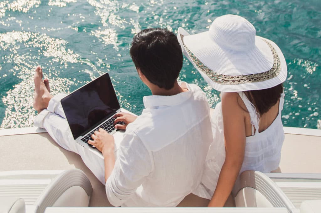 couple on laptop on a boat