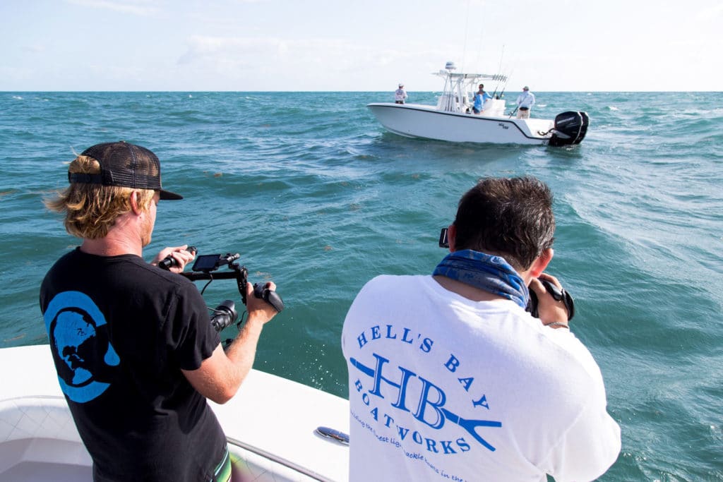 two people taking photos of another boat