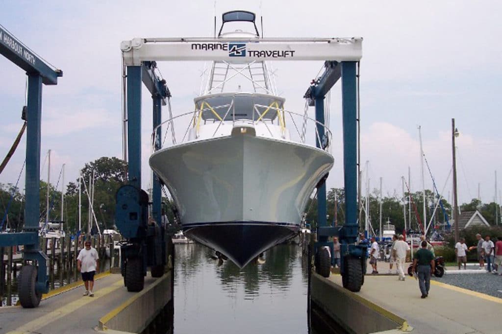 clean boat hoisted above the water