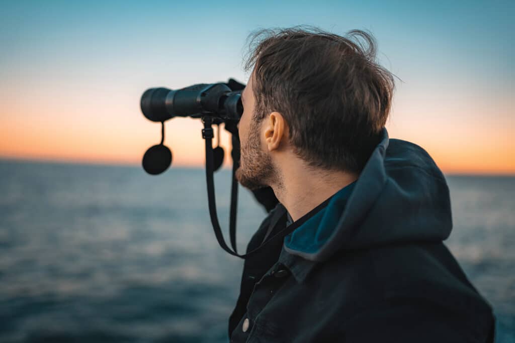 man looking through binoculars