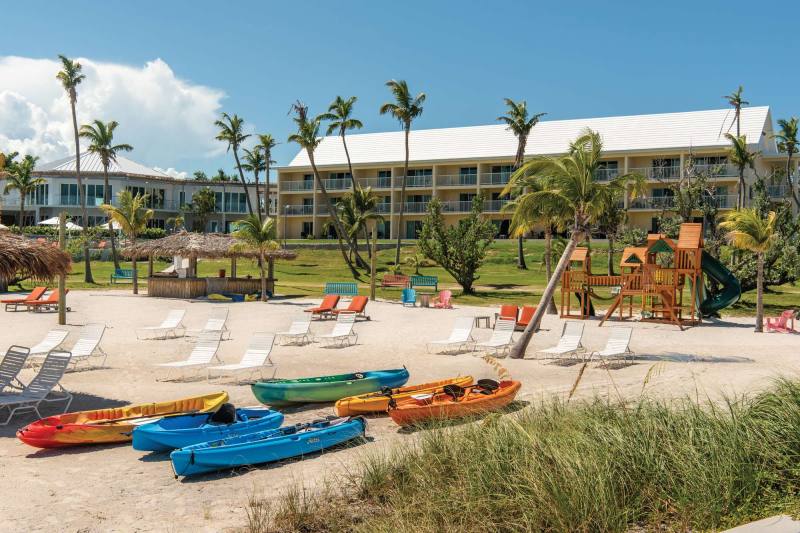 Resort grounds with a row of colorful kayaks on the grass